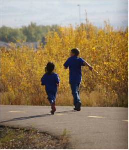 Two children running down a walking path