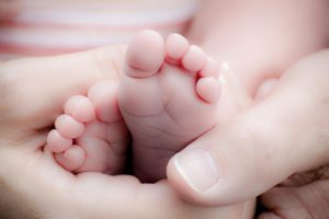 parents hand holding baby feet