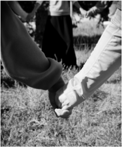 Black and White photo of two people holding hands